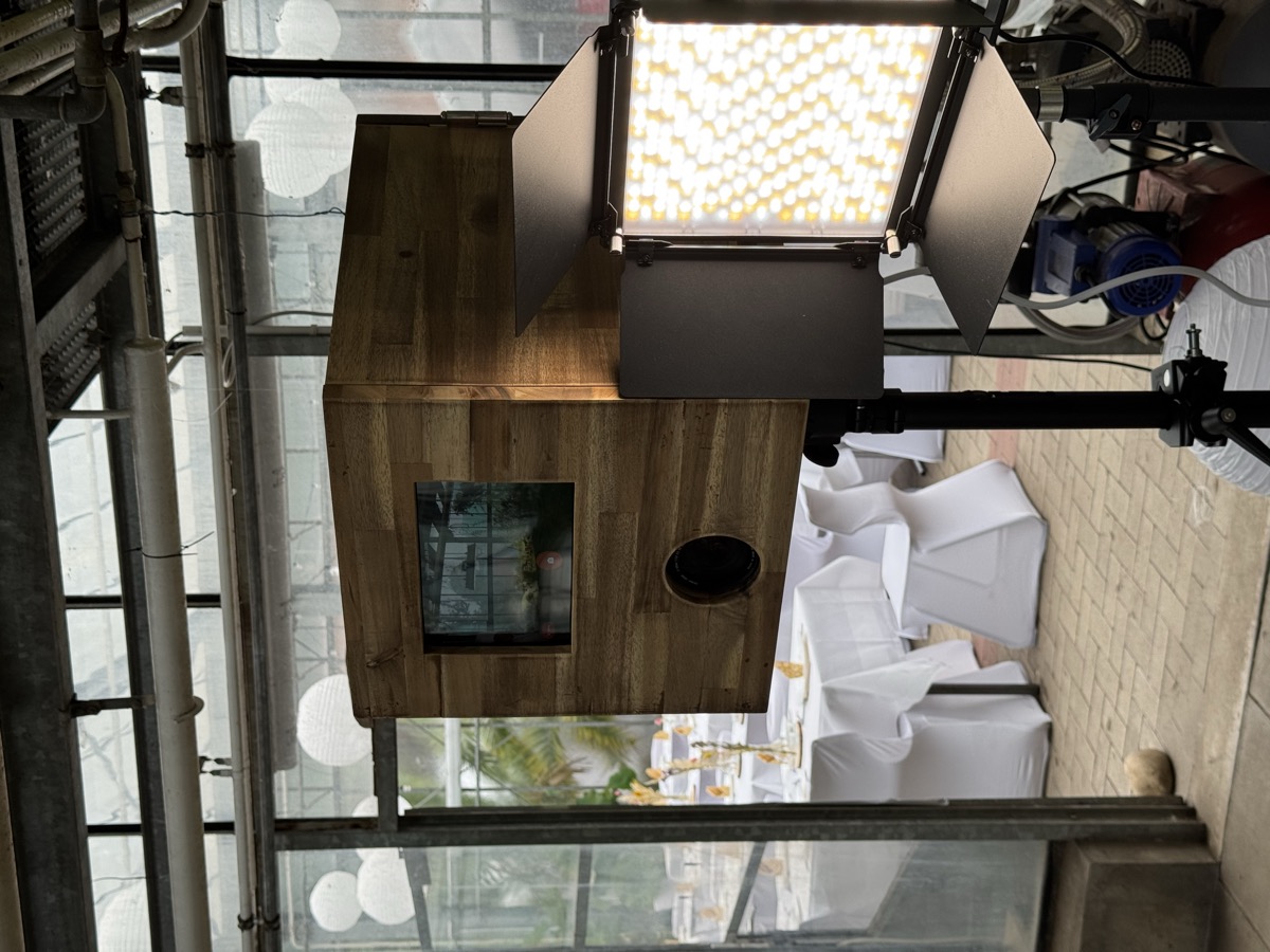 Die Holz-Fotobox mit Fotolicht auf einer Hochzeit im Gewächshaus